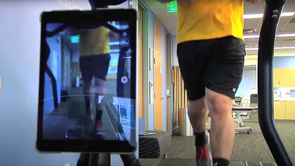 A man walks on a treadmill during a video gait analysis.